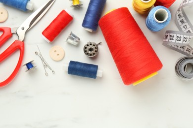 Photo of Flat lay composition with different sewing supplies on white table. Space for text