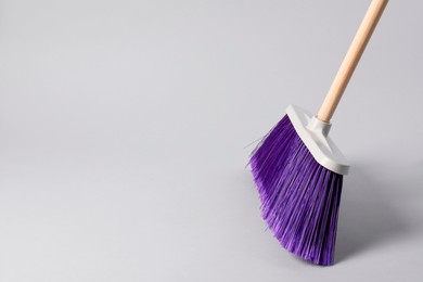 Photo of One cleaning broom on grey background, space for text