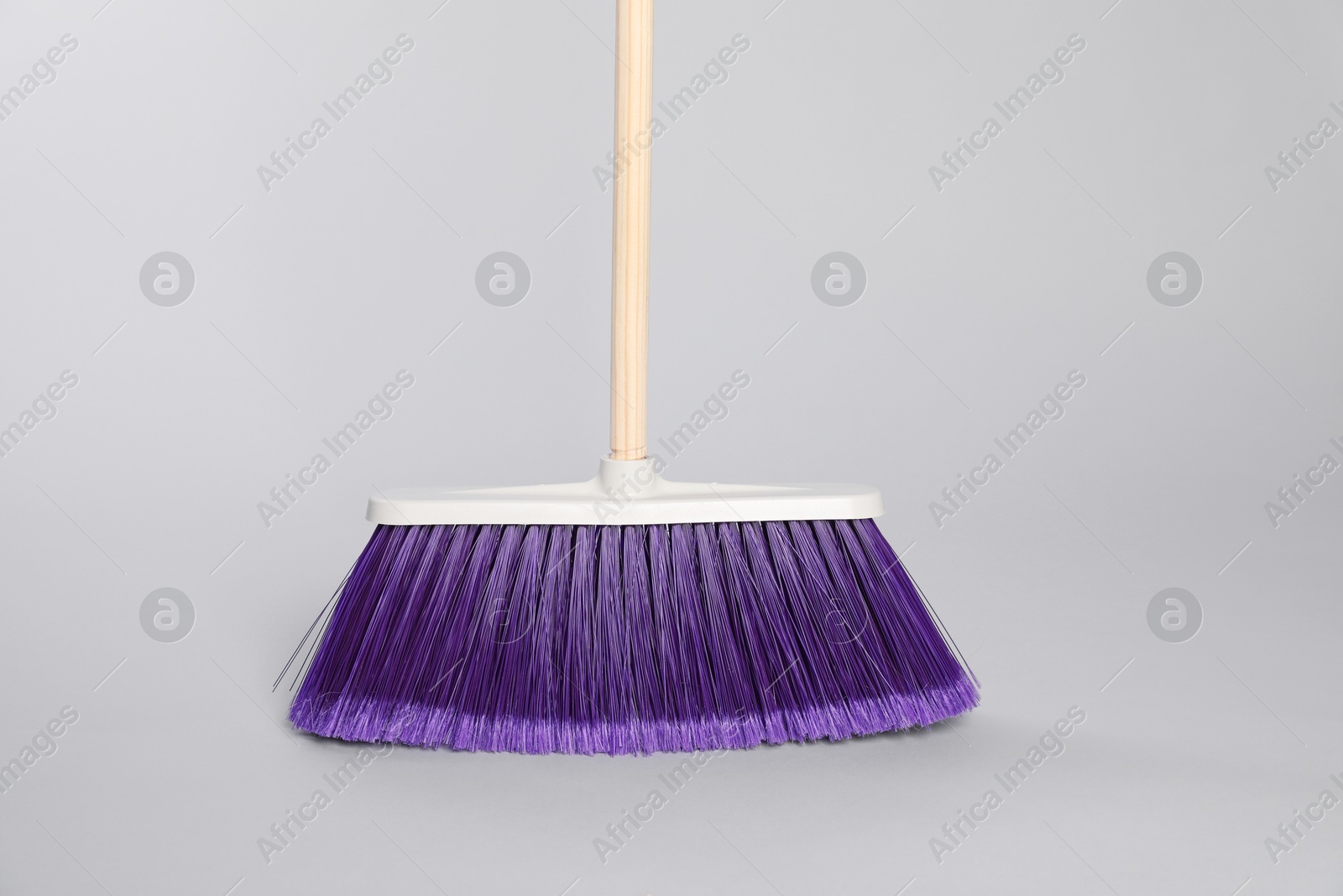 Photo of One bright cleaning broom on grey background