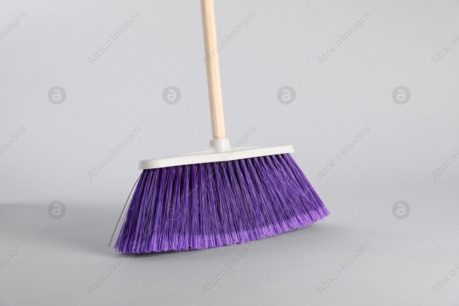 Photo of One bright cleaning broom on grey background