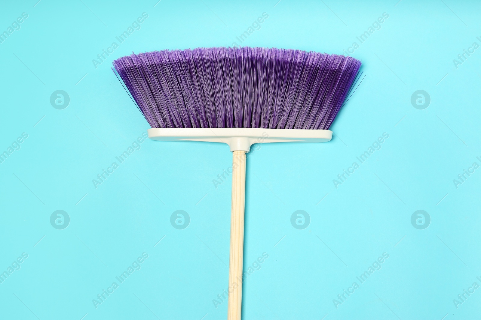 Photo of One cleaning broom on light blue background, top view