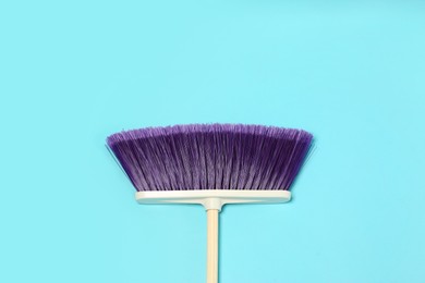 Photo of One cleaning broom on light blue background, top view