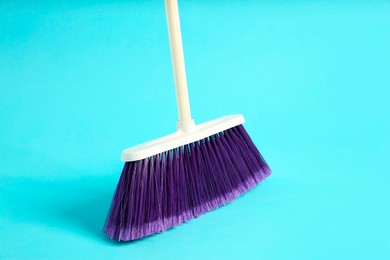 Photo of One cleaning broom on light blue background