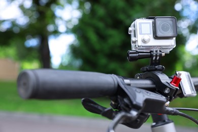 Modern action camera with mount on bicycle outdoors, closeup