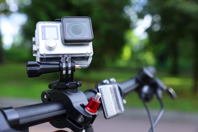 Modern action camera with mount on bicycle outdoors, closeup