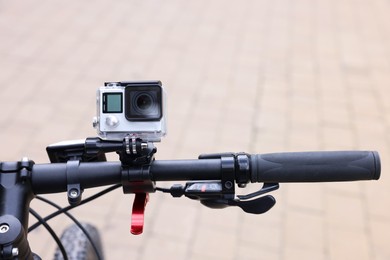 Modern action camera with mount on bicycle outdoors, closeup