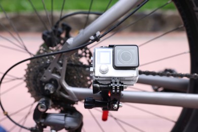 Modern action camera with mount on bicycle outdoors, closeup