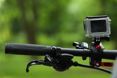 Modern action camera with mount on bicycle outdoors, closeup