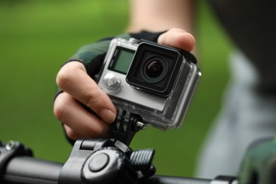 Man with modern action camera on bicycle outdoors, closeup