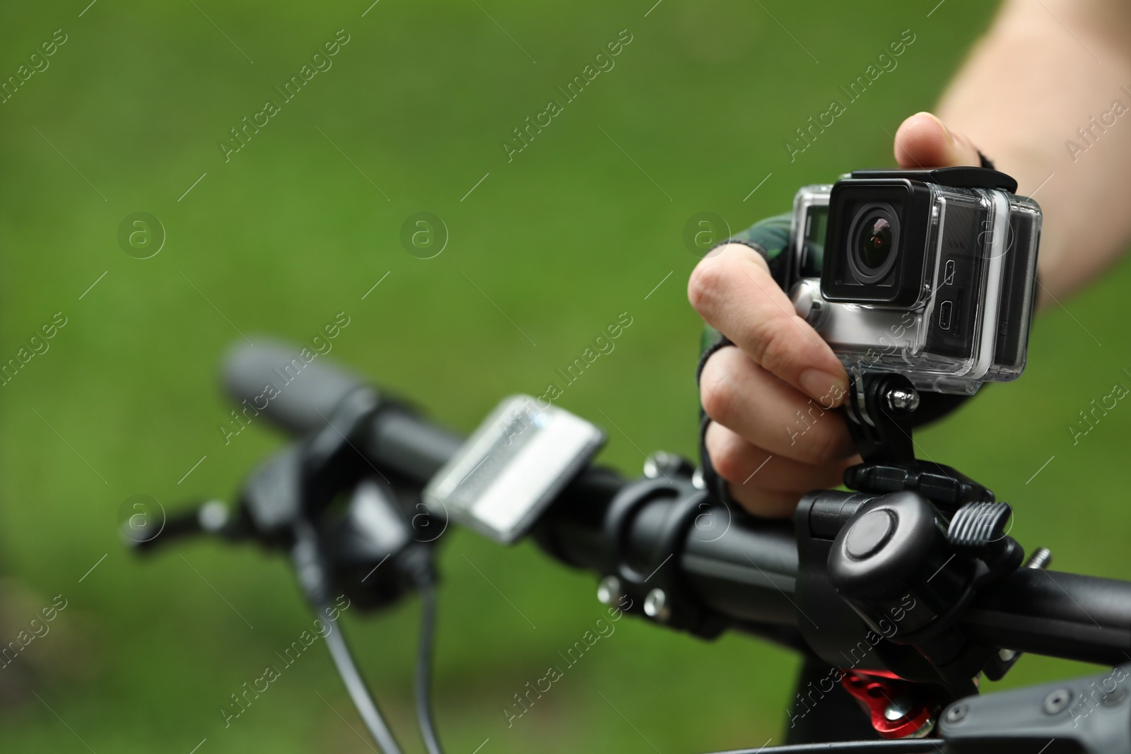 Photo of Man with modern action camera on bicycle outdoors, closeup. Space for text