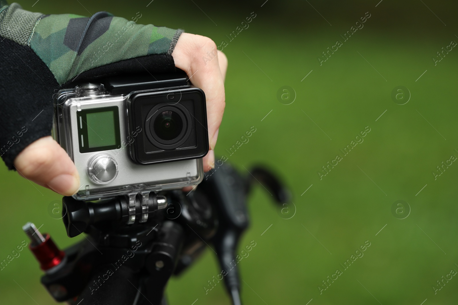 Photo of Man with modern action camera on bicycle outdoors, closeup. Space for text