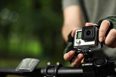 Man with modern action camera on bicycle outdoors, closeup