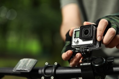 Man with modern action camera on bicycle outdoors, closeup