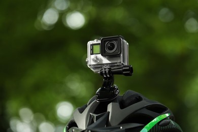 Modern action camera with mount on helmet outdoors, closeup