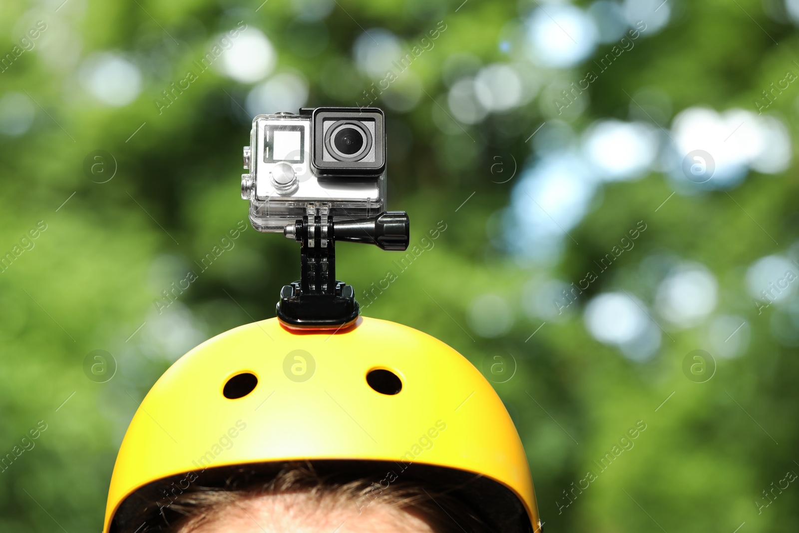 Photo of Man with modern action camera on helmet outdoors, closeup. Space for text