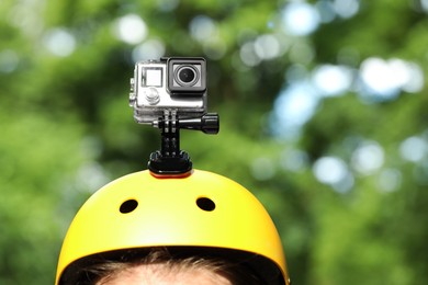 Man with modern action camera on helmet outdoors, closeup. Space for text