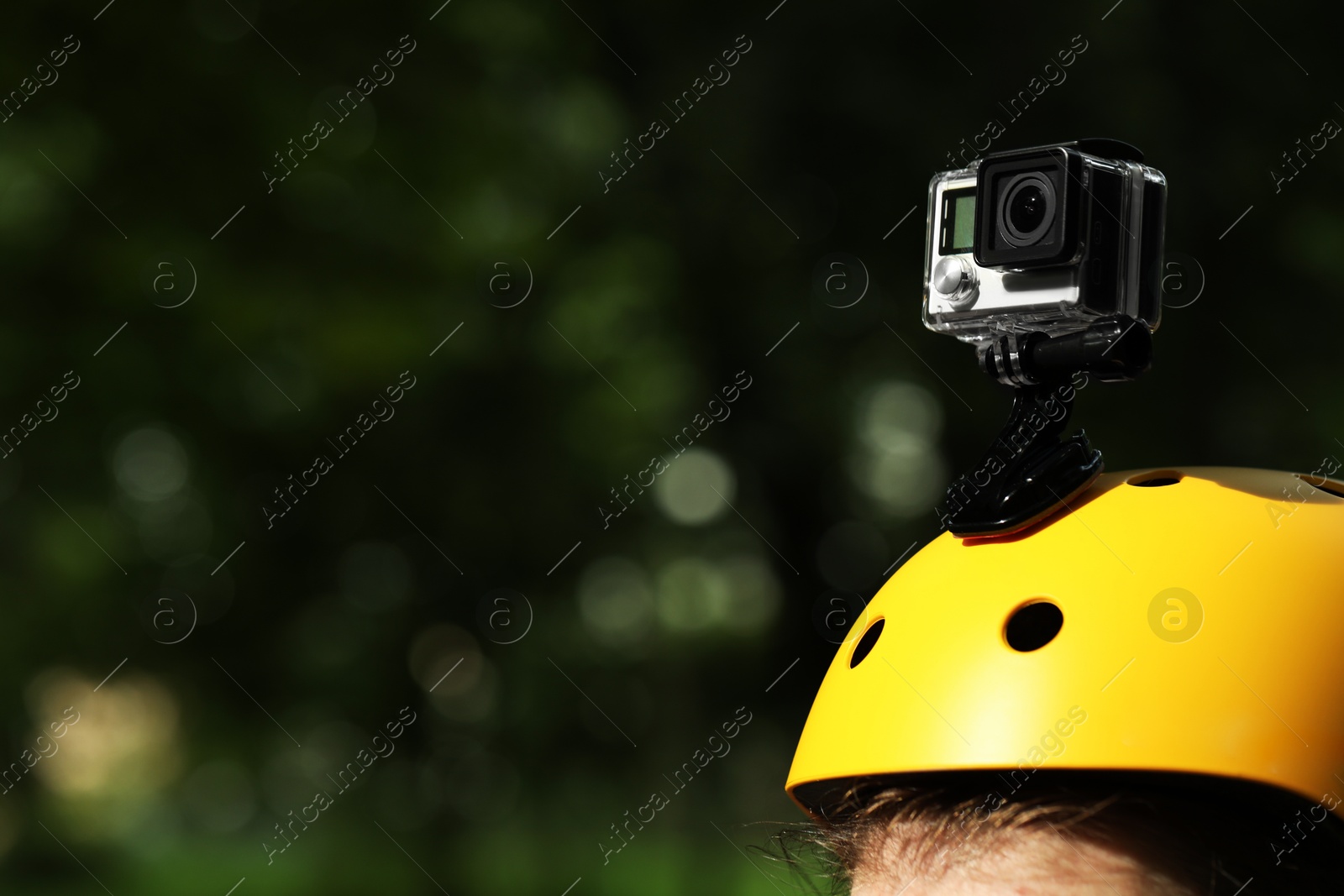 Photo of Man with modern action camera on helmet outdoors, closeup. Space for text