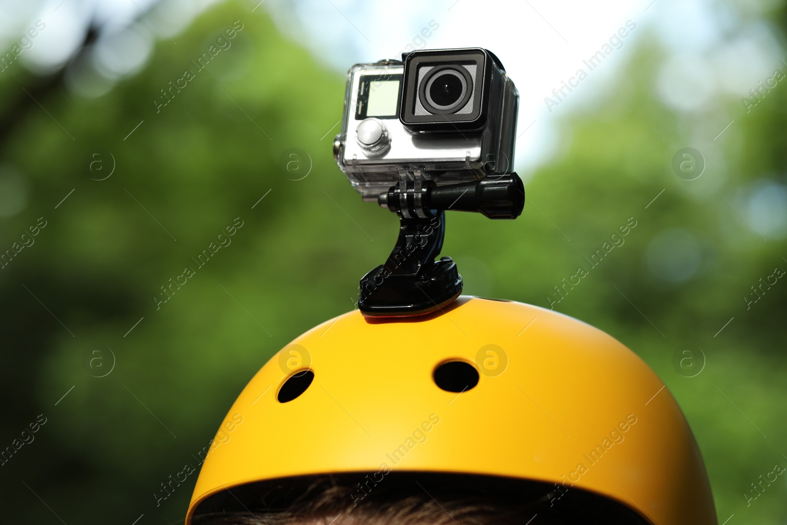 Photo of Man with modern action camera on helmet outdoors, closeup