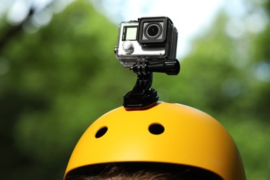 Photo of Man with modern action camera on helmet outdoors, closeup