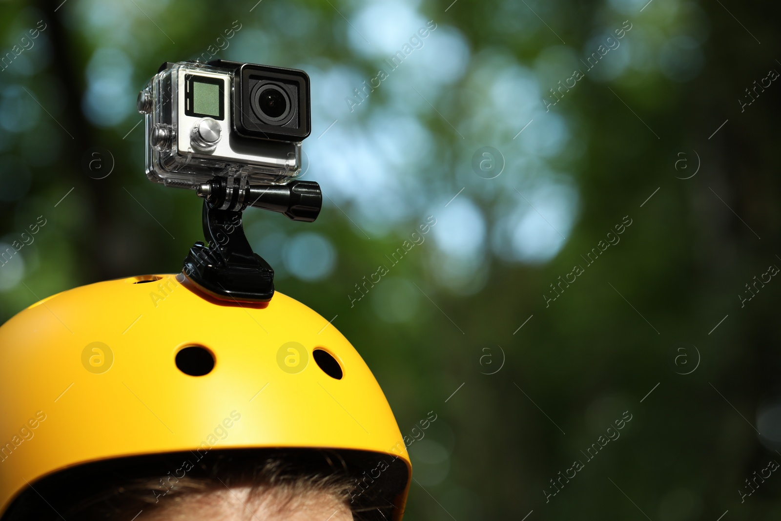 Photo of Man with modern action camera on helmet outdoors, closeup. Space for text