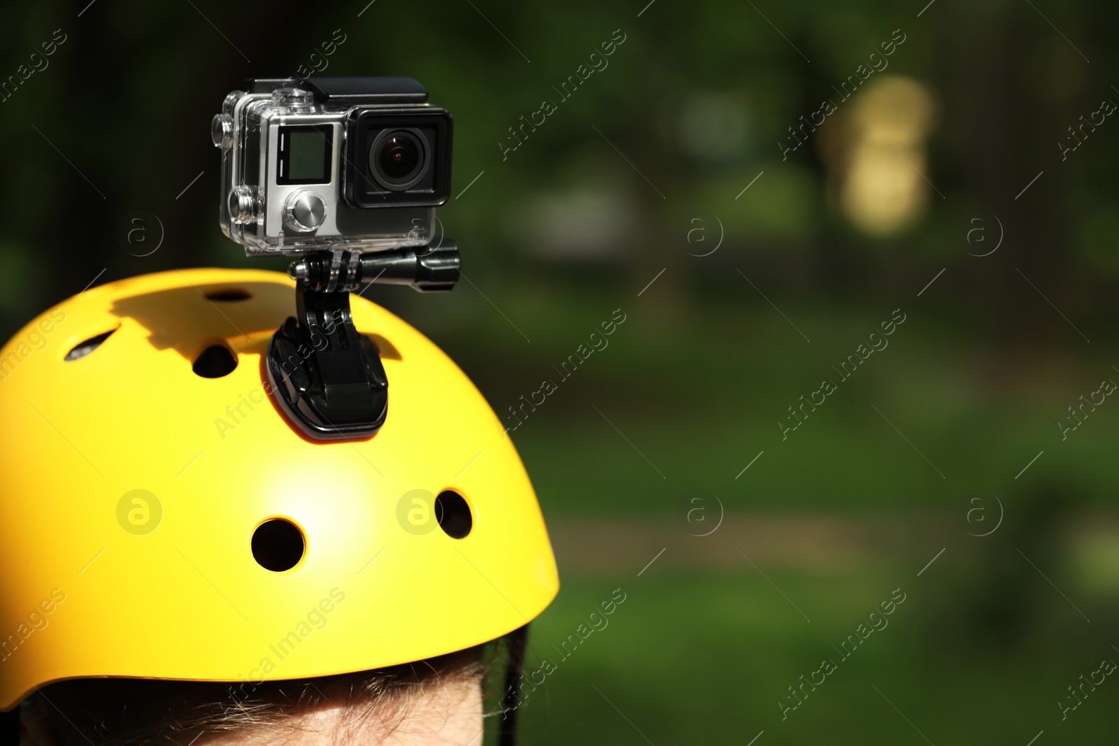 Photo of Man with modern action camera on helmet outdoors, closeup. Space for text