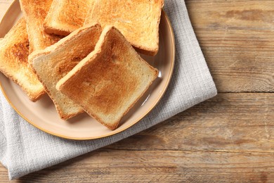 Photo of Delicious toasts on wooden table, top view