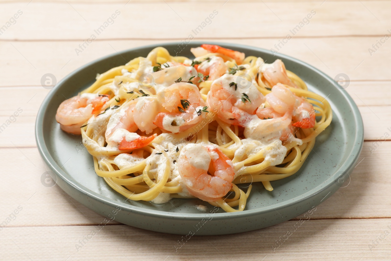 Photo of Delicious pasta with shrimps on white wooden table, closeup