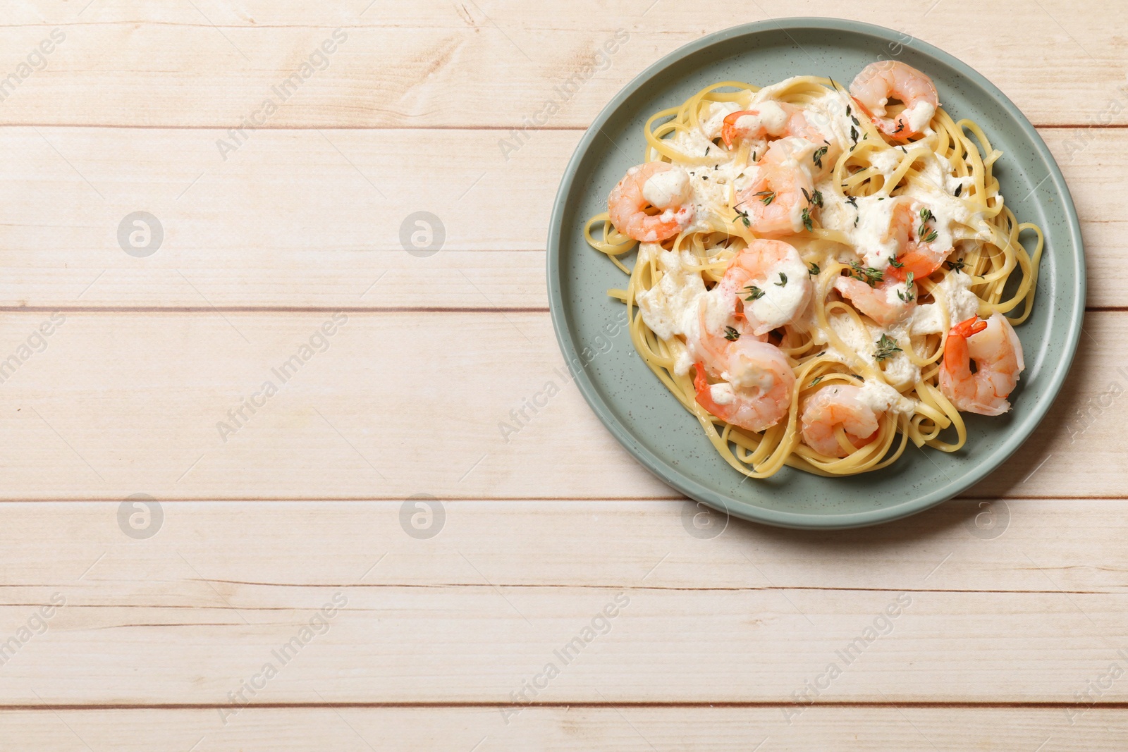 Photo of Delicious pasta with shrimps on white wooden table, top view. Space for text