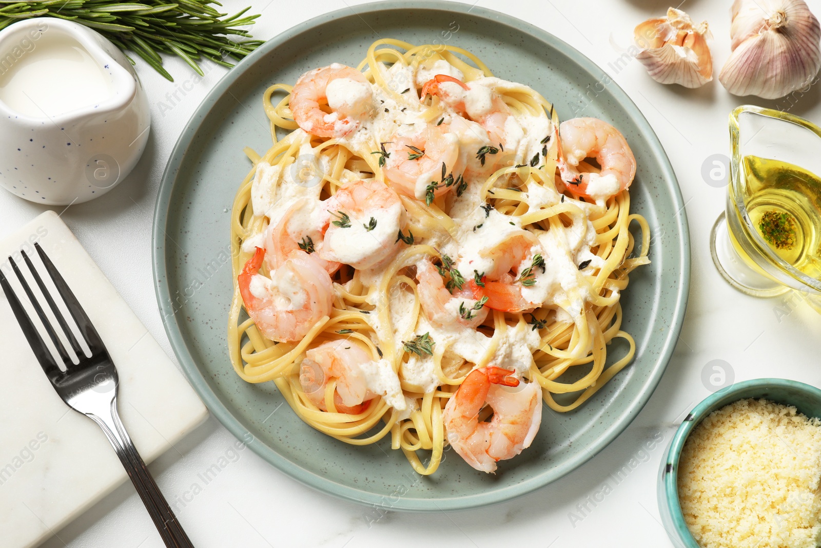 Photo of Delicious pasta with shrimps served on white table, flat lay