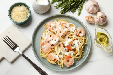 Photo of Delicious pasta with shrimps served on white table, flat lay