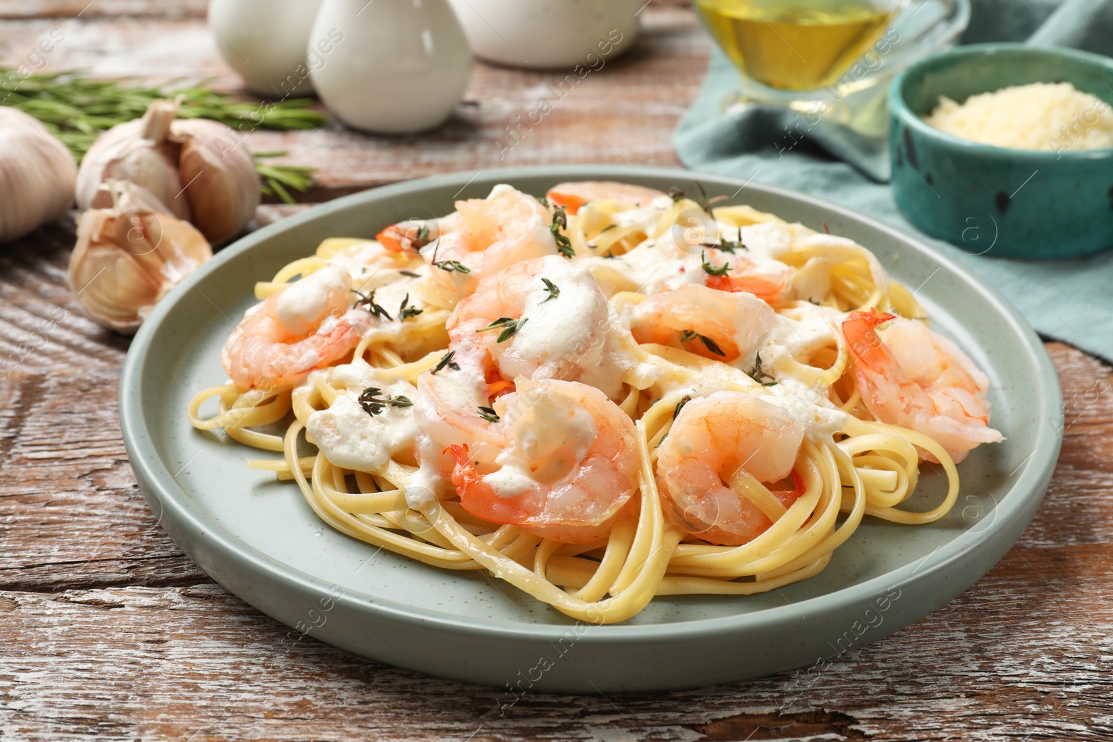 Photo of Delicious pasta with shrimps served on wooden table, closeup