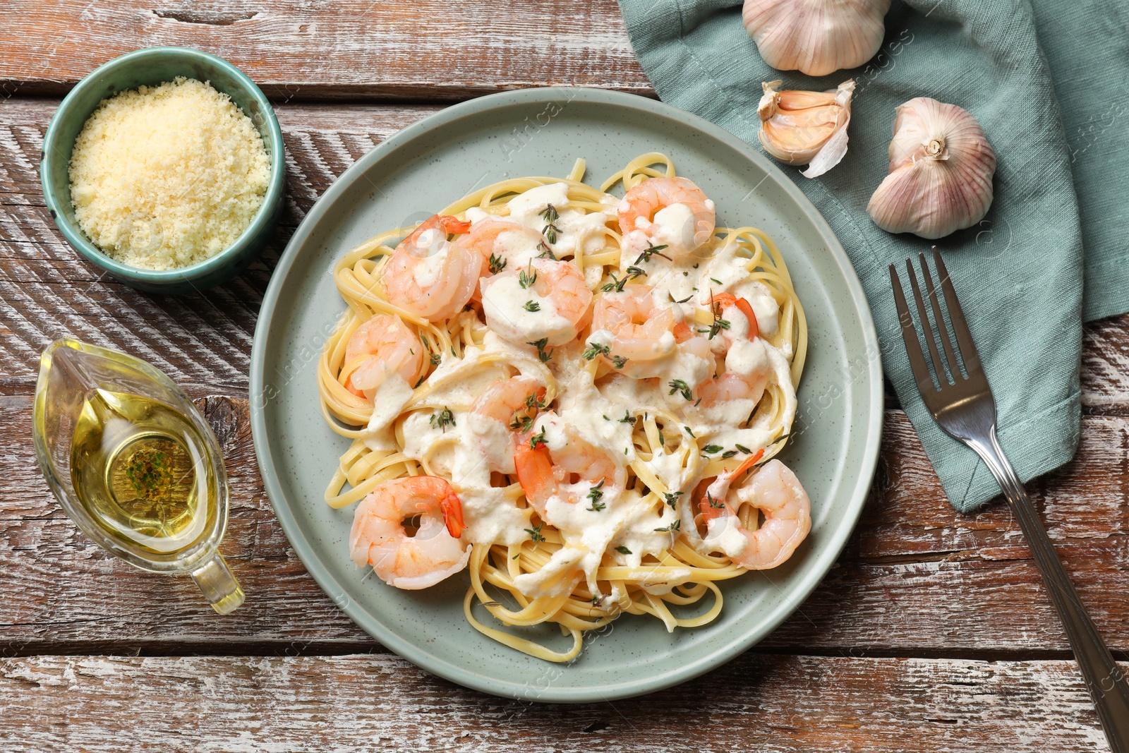 Photo of Delicious pasta with shrimps served on wooden table, flat lay