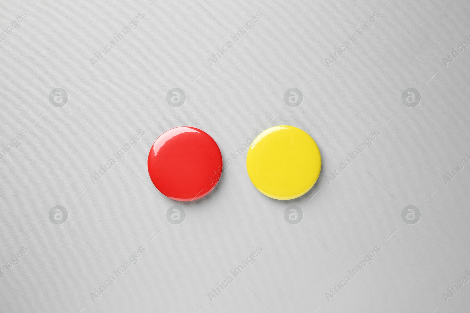 Photo of Blank colorful button badges on grey background, top view. Mockup for design