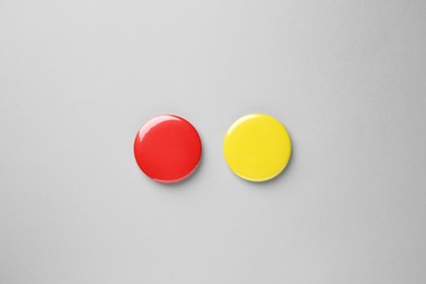 Blank colorful button badges on grey background, top view. Mockup for design