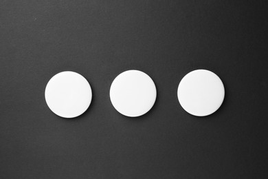 Photo of Blank white button badges on black background, top view. Mockup for design