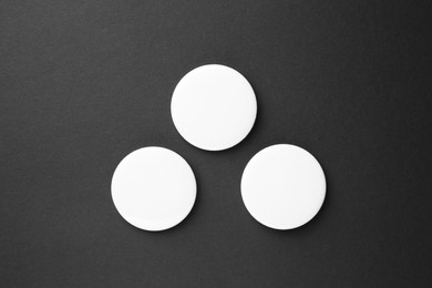 Photo of Blank white button badges on black background, top view. Mockup for design