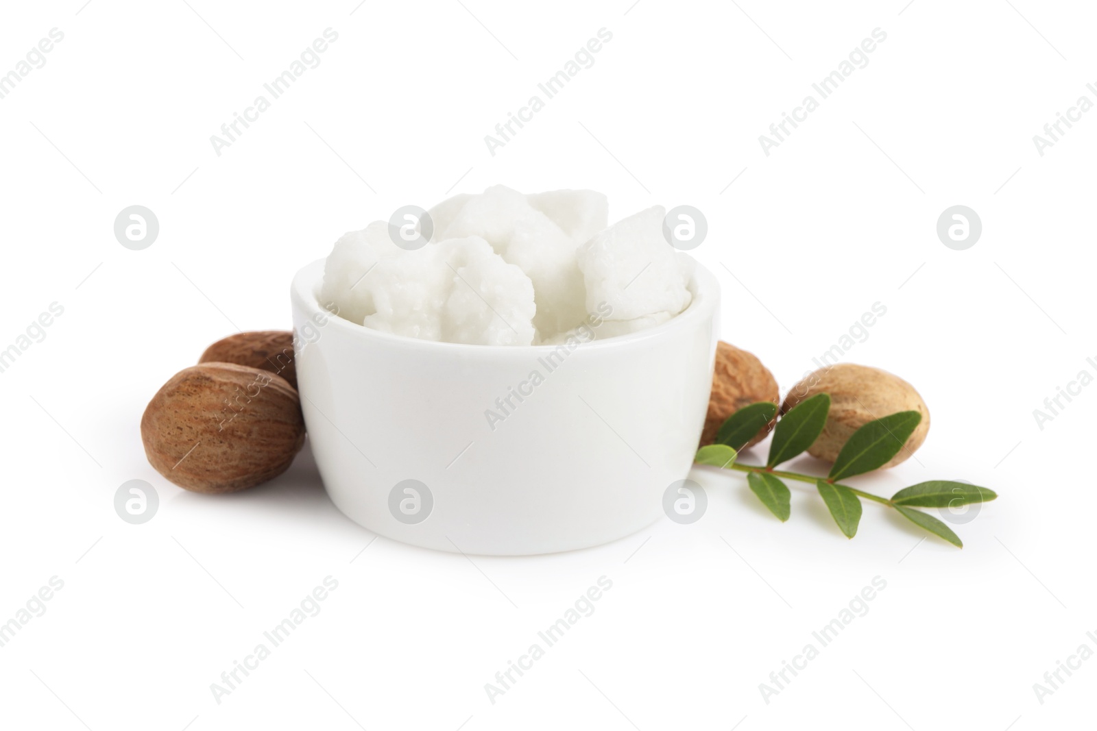 Photo of Shea butter in bowl and nuts isolated on white