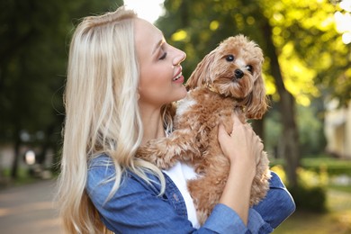 Beautiful young woman with cute dog in park