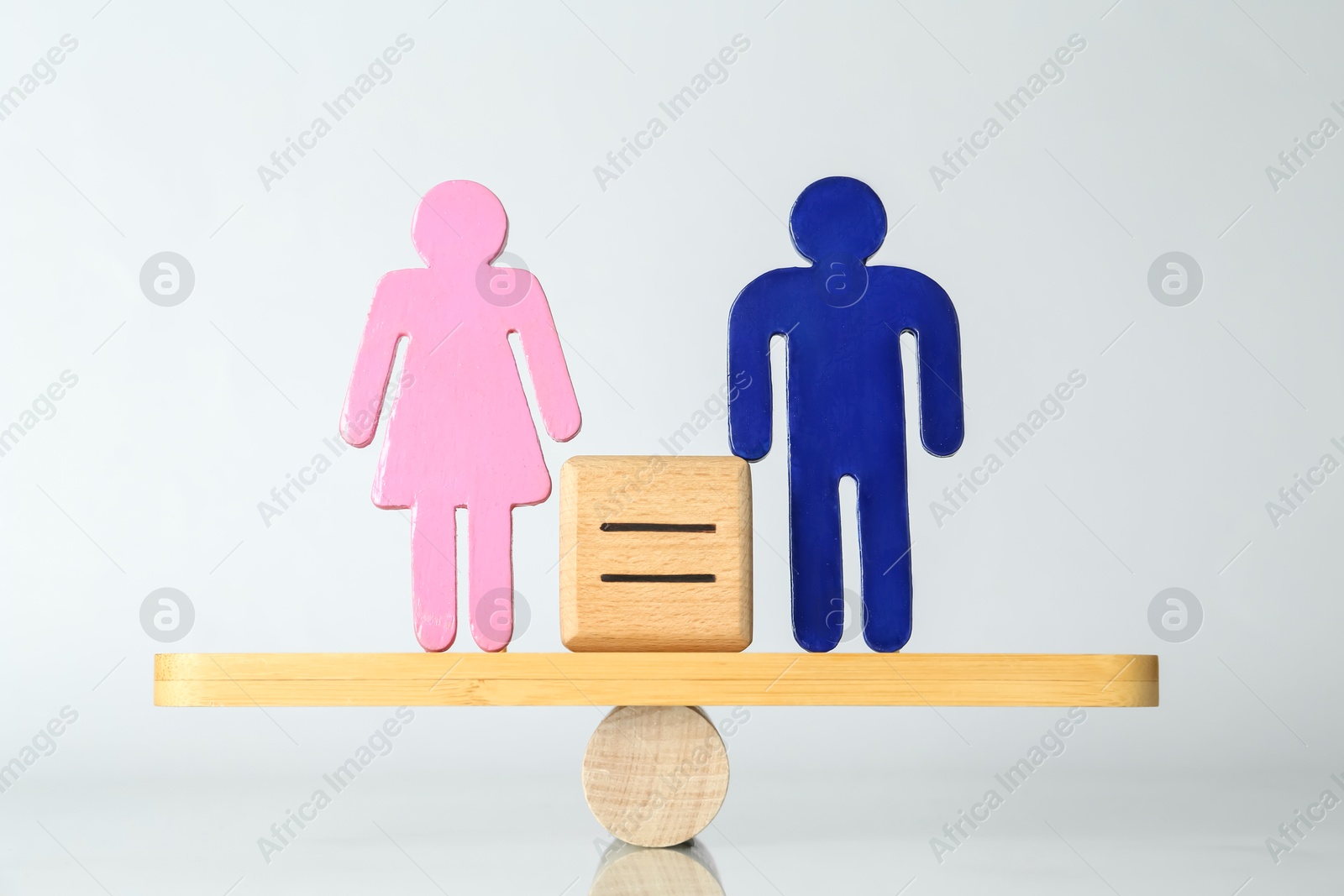 Photo of Gender equality concept. Male and female figures on scales against light background