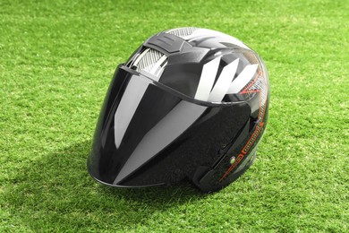 Modern motorcycle helmet with visor on green grass outdoors