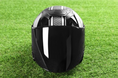 Modern motorcycle helmet with visor on green grass outdoors