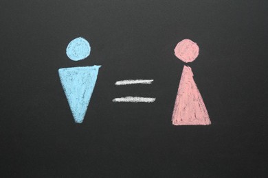 Gender equality concept. Male and female figures drawn on chalkboard, top view