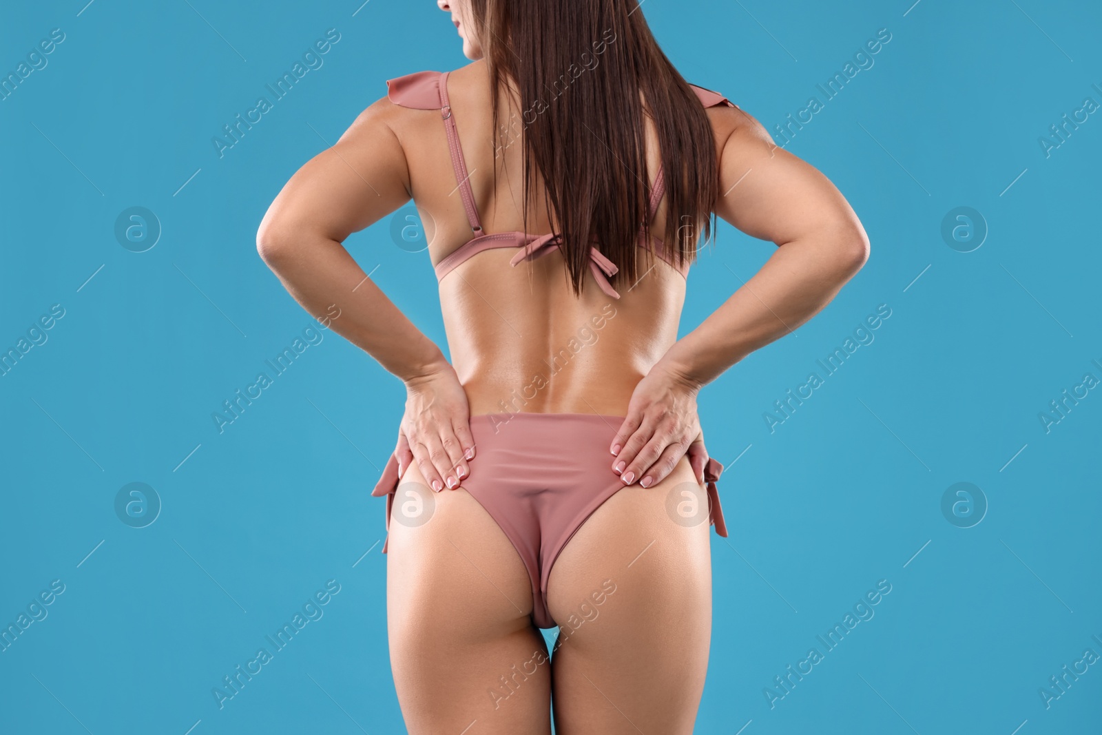 Photo of Woman in bikini on light blue background, closeup