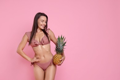 Photo of Woman in stylish bikini with fresh pineapple on pink background, space for text