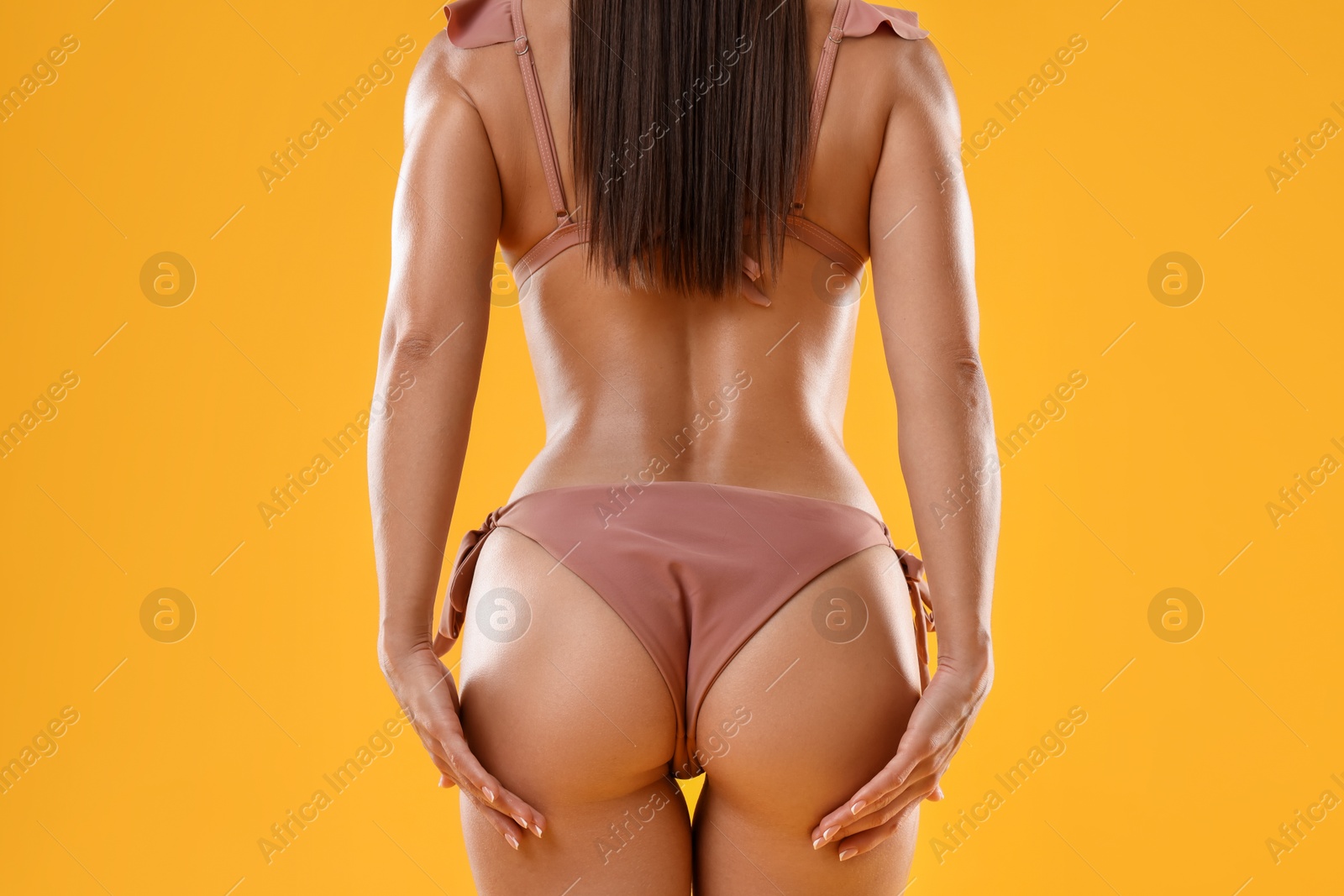 Photo of Woman in stylish bikini on orange background, closeup