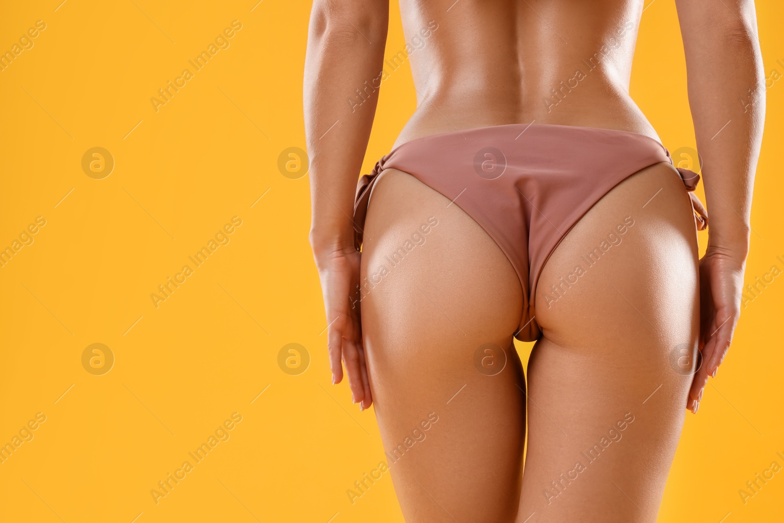 Photo of Woman in stylish bikini on orange background, closeup. Space for text