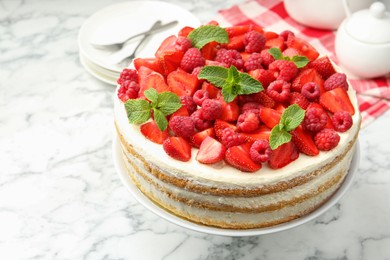 Photo of Tasty sponge cake with fresh berries and mint on white marble table, closeup