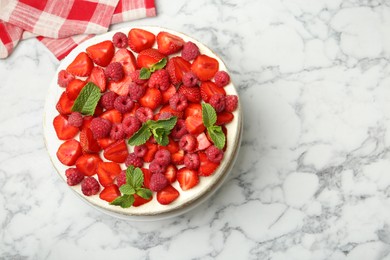 Photo of Tasty sponge cake with fresh berries and mint on white marble table, top view. Space for text