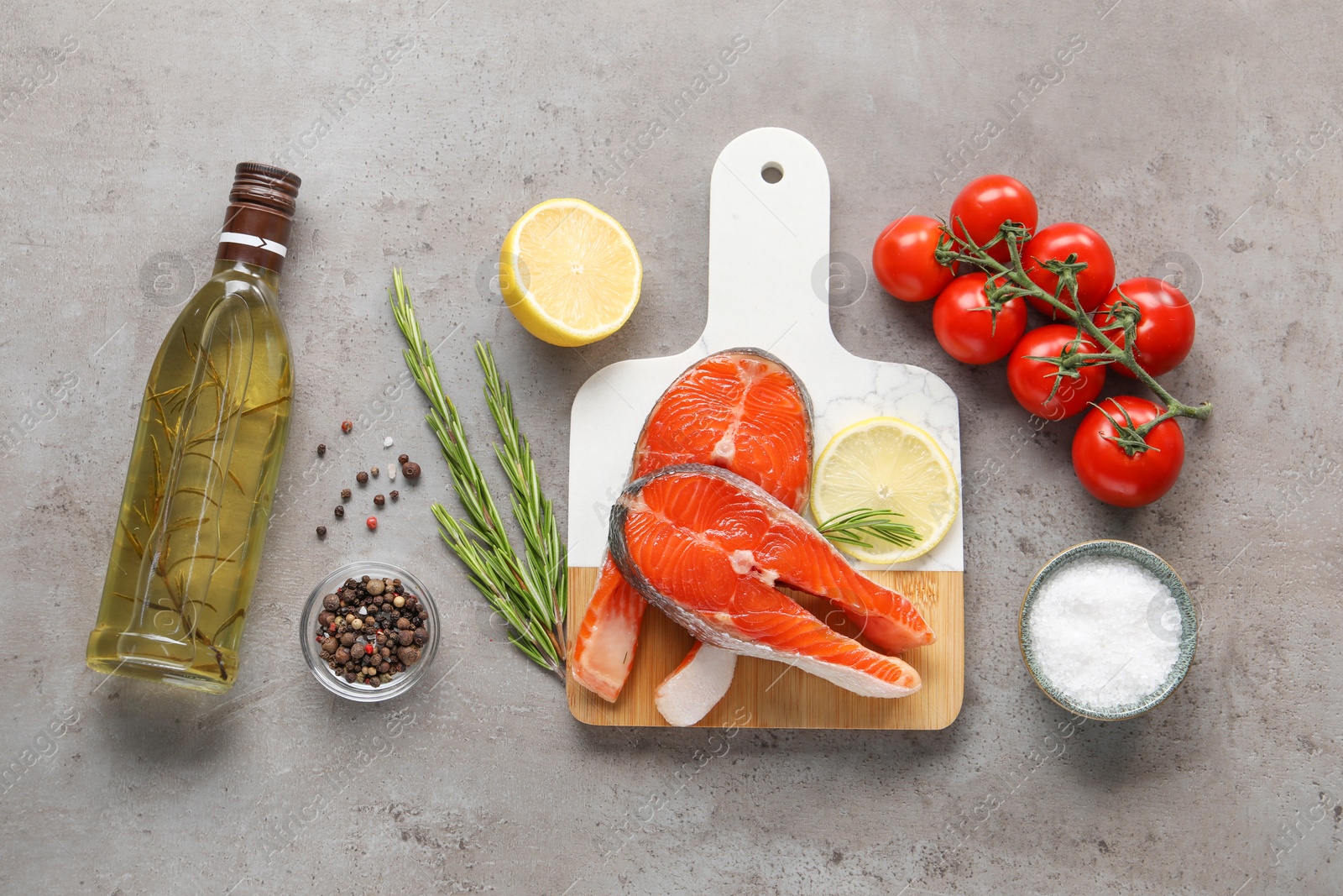 Photo of Flat lay composition with fresh salmon steaks on grey textured table