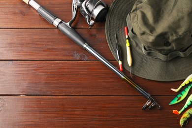 Fishing tackle and hat on wooden background, flat lay. Space for text